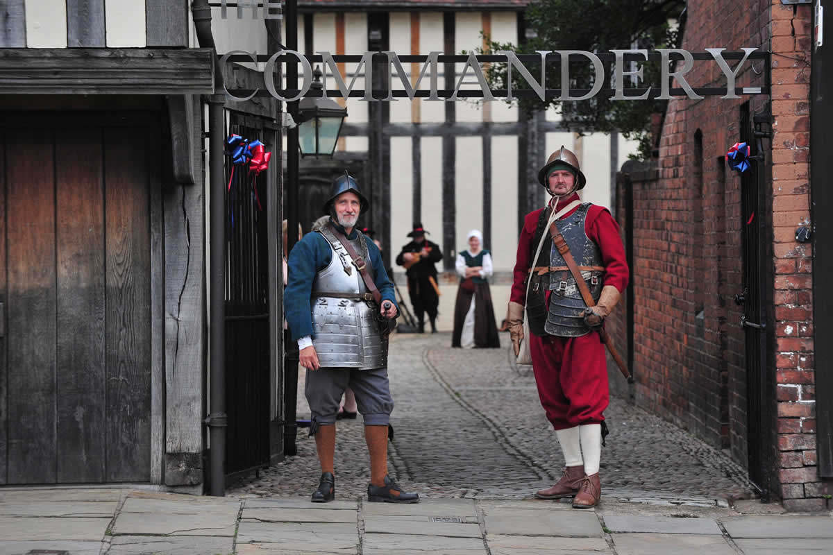 Two living history actors stand in front of The Commandery entrance.