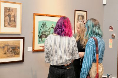 Two girls being guided through an exhibition by a curator in Worcester City Art Gallery & Museum.