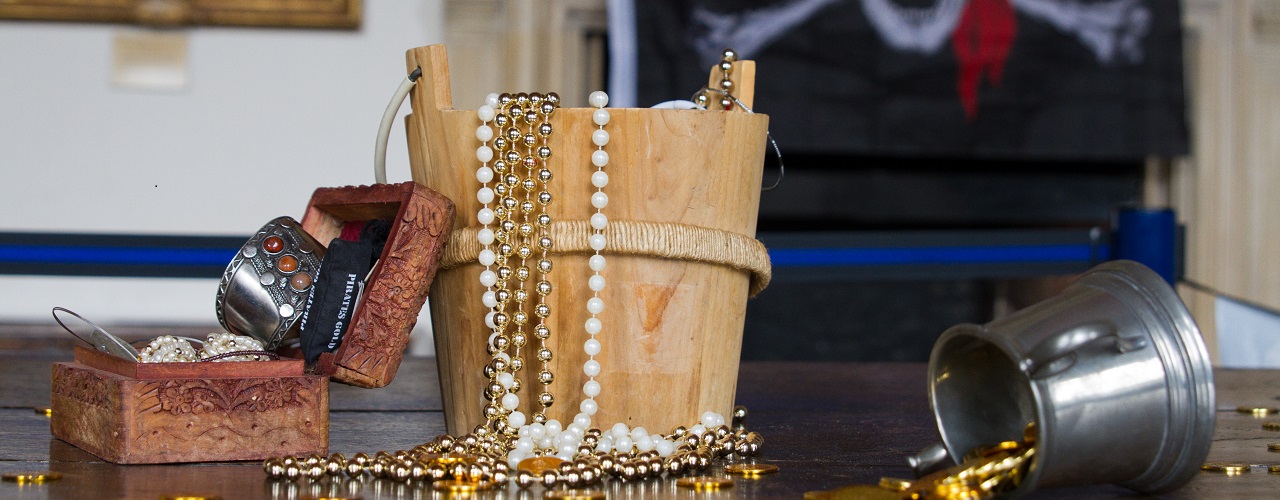 A bucket of gold and a skull & crossbones flag.