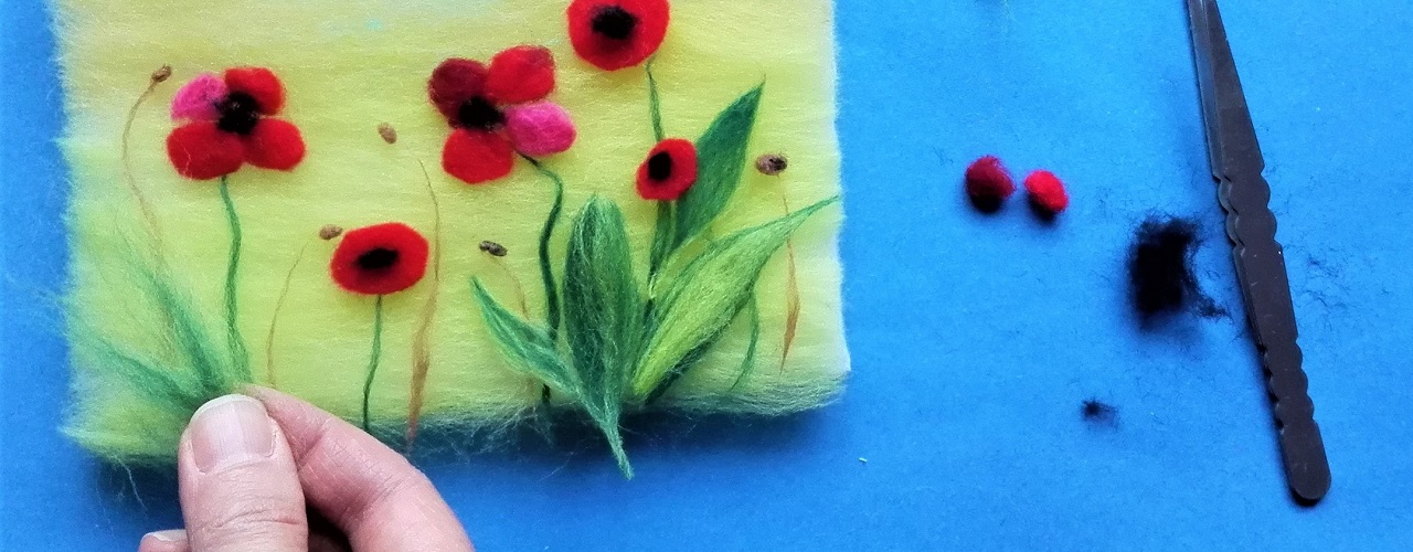laying down poppy shapes on a wool craft piece