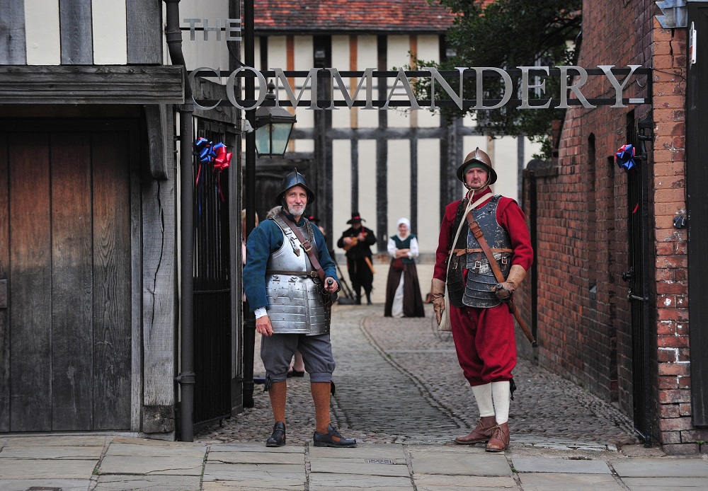 A photo of The Commandery's entrance gate with two reenactors ready to greet visitors for a great day of things to do at The Commandery.