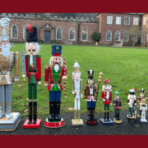 A photo showing several nutcracker soldier models from the family trail lined up in size order in front of Hartlebury Castle.