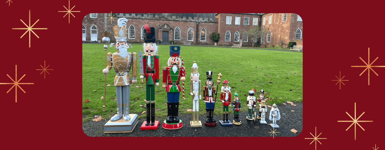 A photo showing several nutcracker soldier models from the family trail lined up in size order in front of Hartlebury Castle.