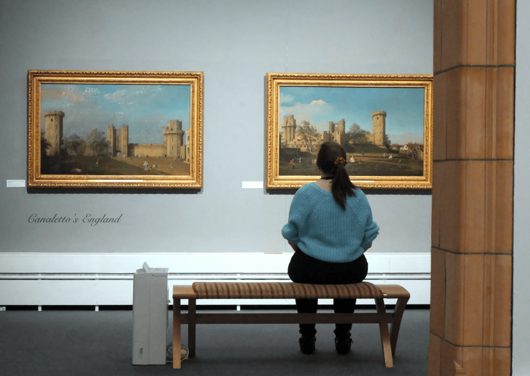 A photo of a visitor sitting in the Canaletto: A Venetian's View exhibition at Worcester City Art Gallery and Museum.