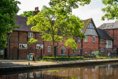 A photo showing The Commandery's building on a summer's day from across the canal.