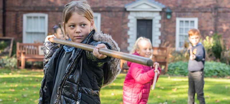 A photo showing school children taking part in a pike drill in the garden at The Commandery.