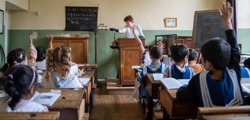 A Victorian schoolmistress teaching a class of children.