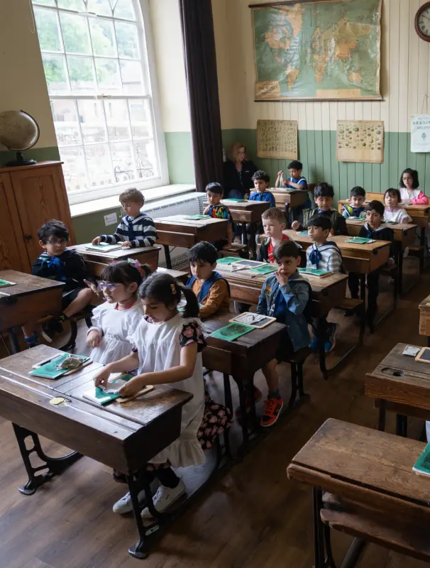 A photo showing children sitting in the Victorian schoolroom at Hartlebury Castle.