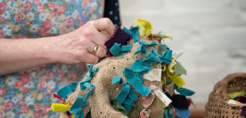 A photo showing the hands of someone creating from scraps.